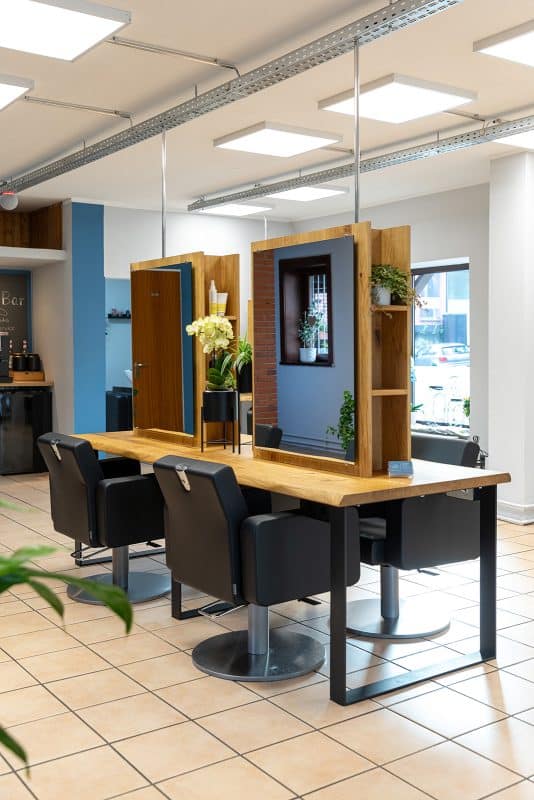 Zwei nebeneinander liegende Spiegel in einem Haarwerk. 