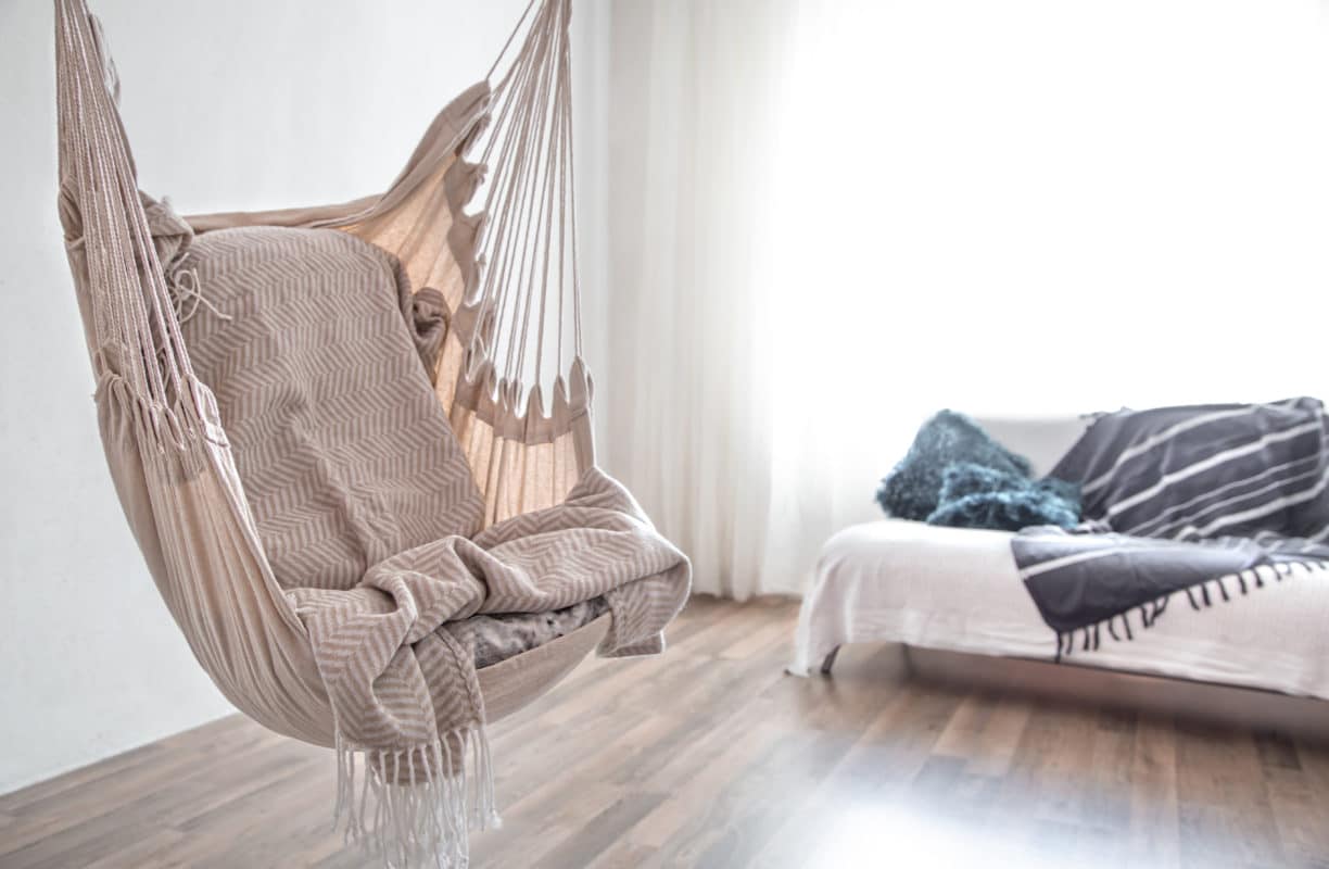 Schlafzimmer im Bohostil mit Hängesitz.