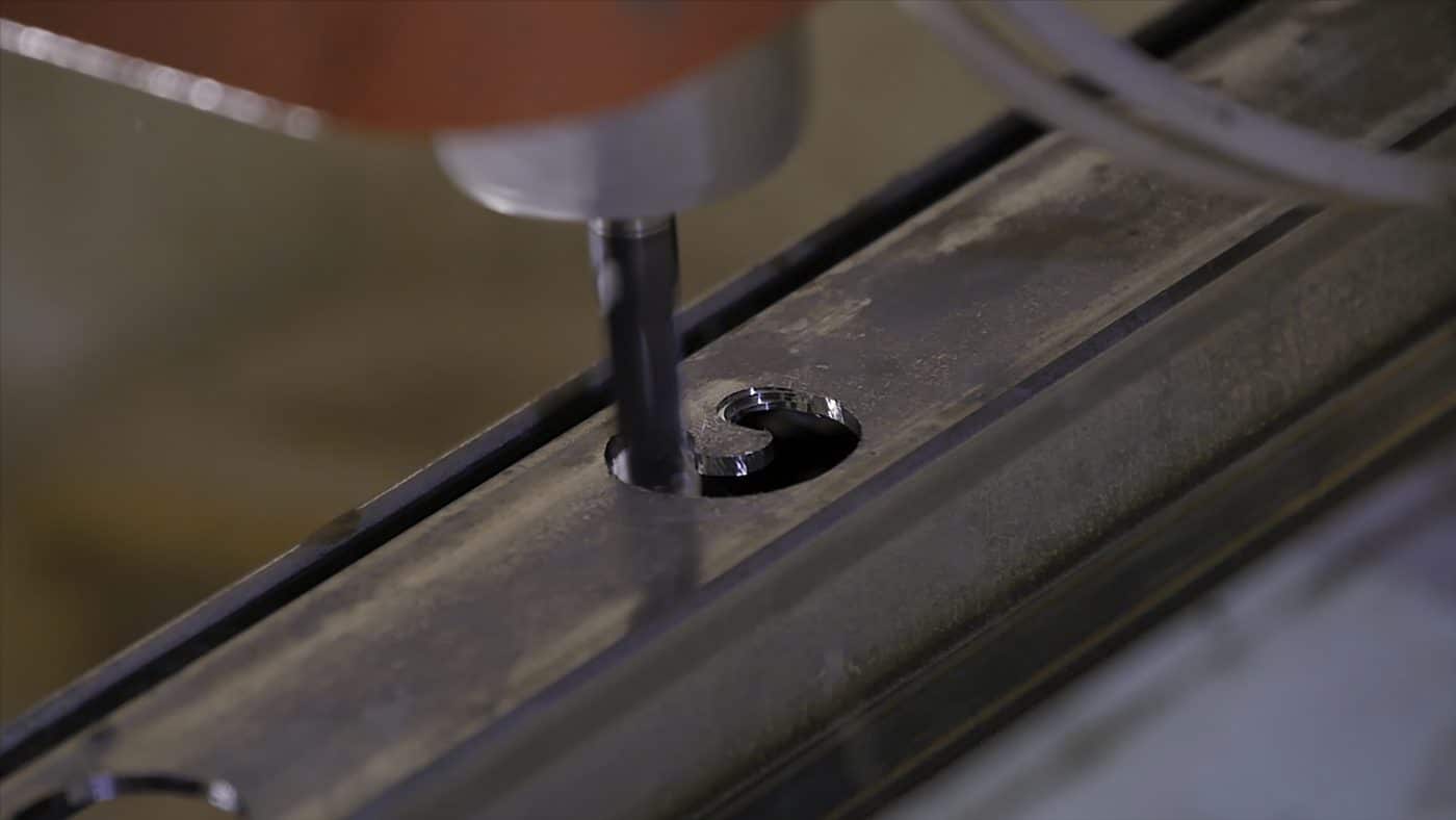 Fräsvorgang schneidet präzises Motiv in Metallprofil.