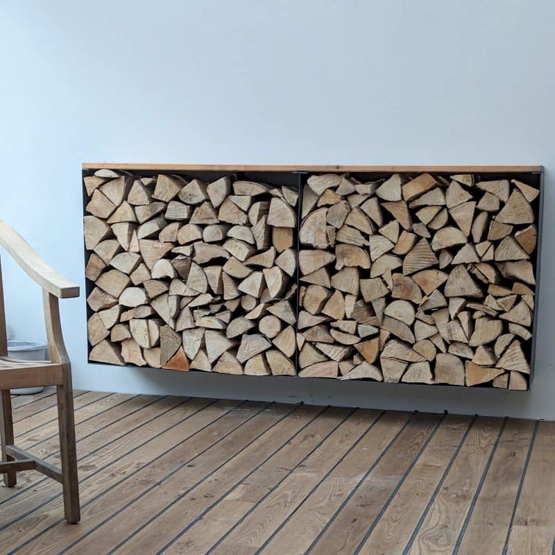 Ein wandhängendes Regal ist ordentlich mit gespaltenem Kaminholz gefüllt.
