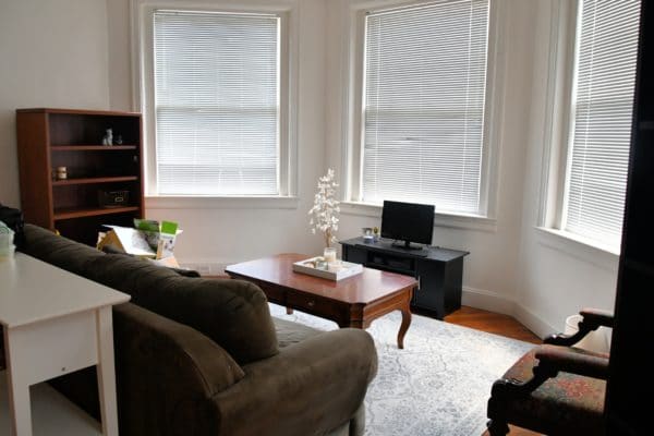 Kleines Wohnzimmer mit Sofa, Couchtisch und TV.