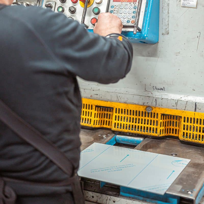 Eine Person bedient ein industrielles Steuerpult für Maschinenarbeiten.