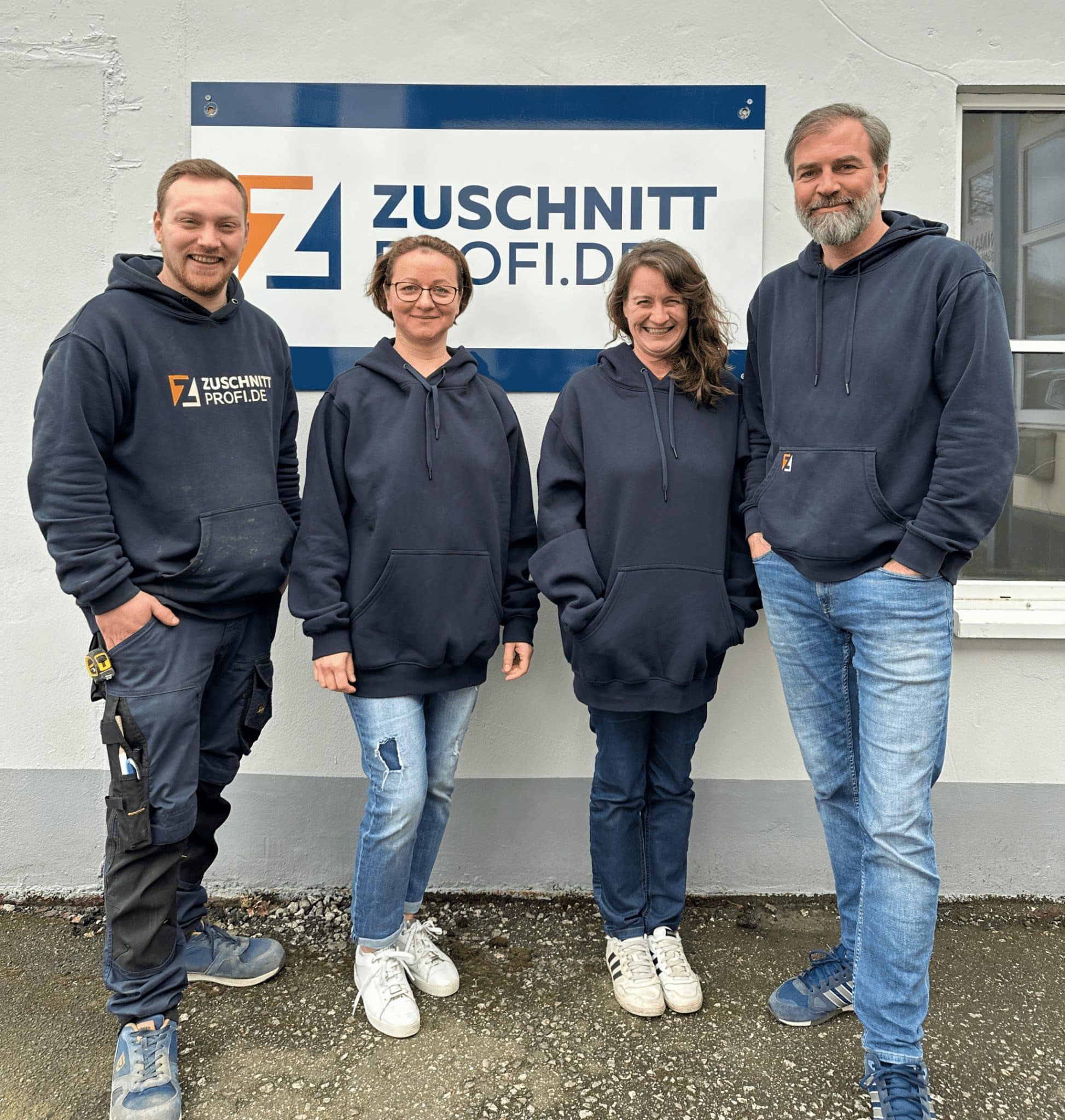 Vier Teammitglieder von zuschnittprofi.mom posieren gemeinsam vor dem Firmengebäude.