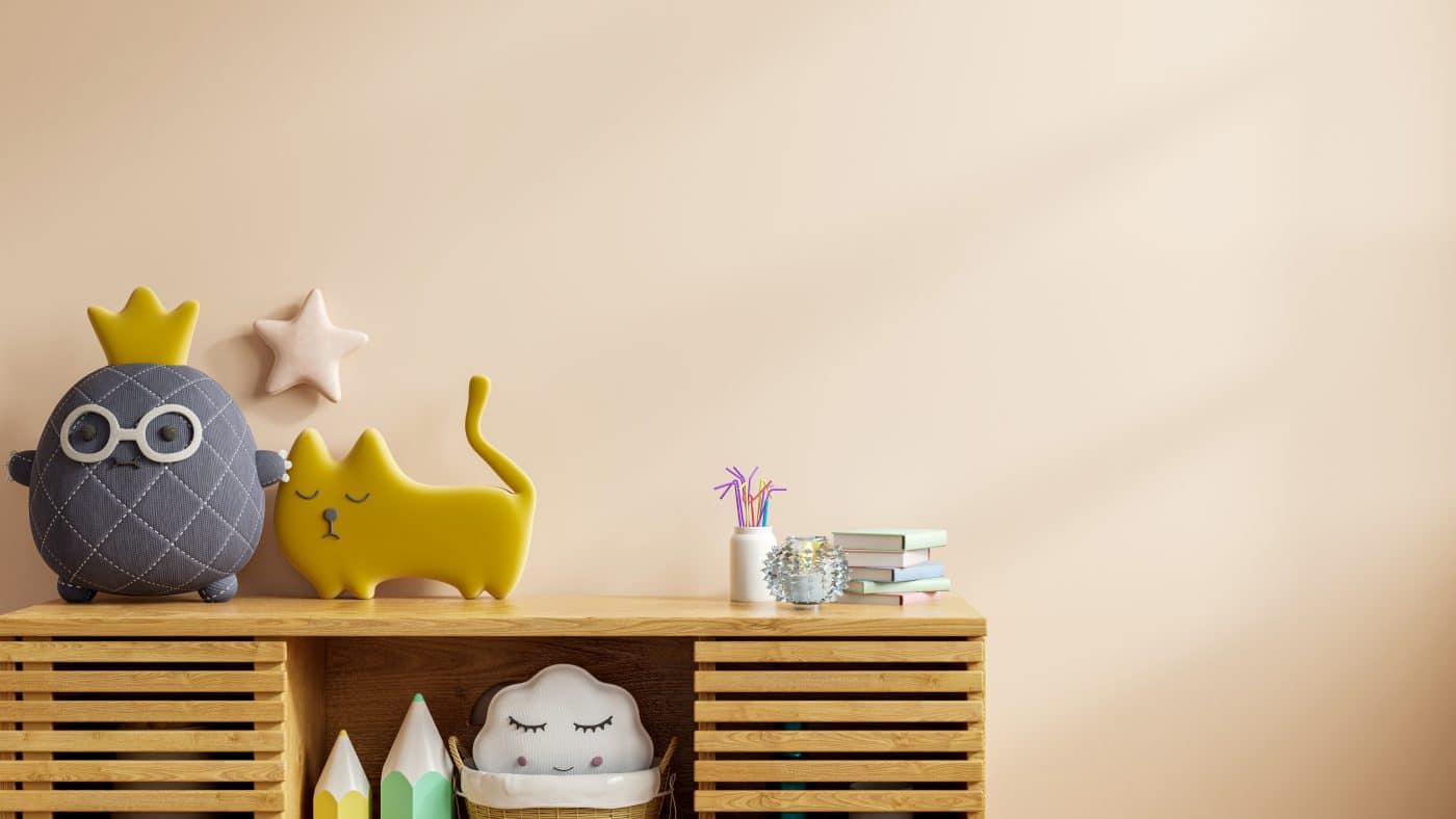 Niedliche Dekofiguren und Bücher auf Holzregal im Kinderzimmer.