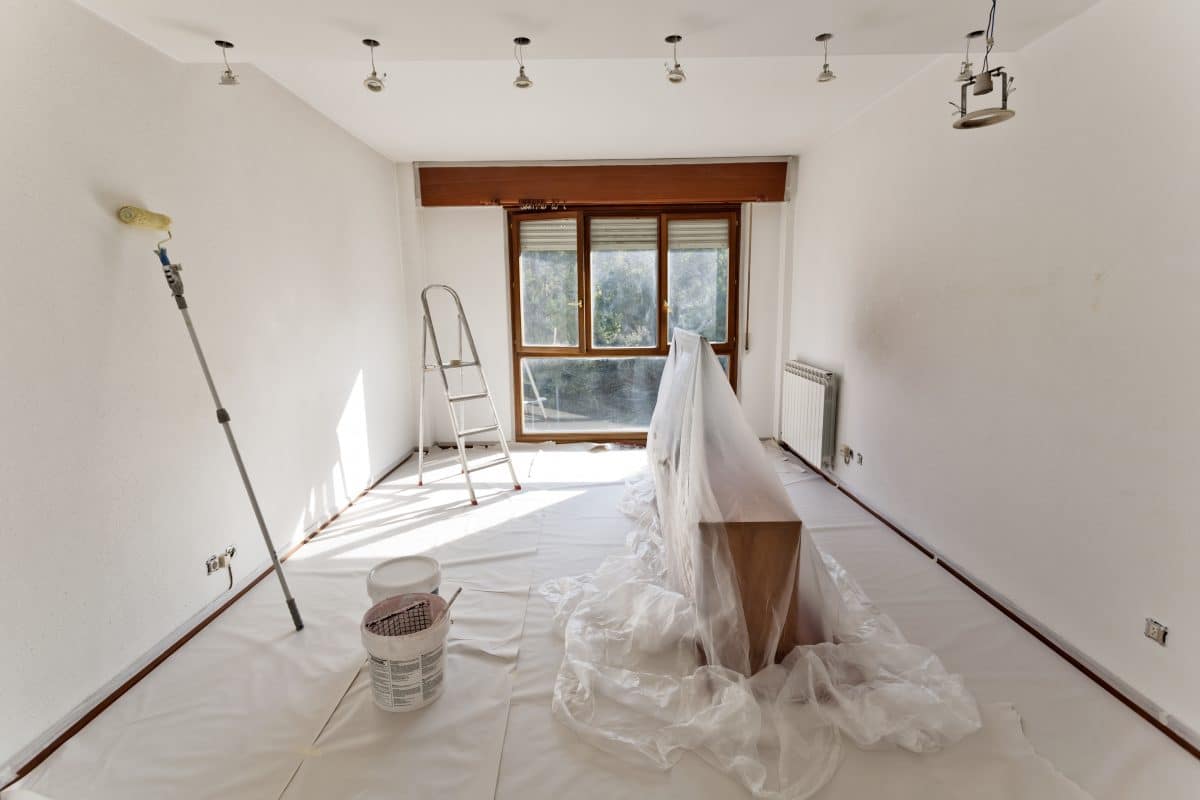 Leeres Zimmer mit Malerutensilien für Renovierungsarbeiten vorbereitet.