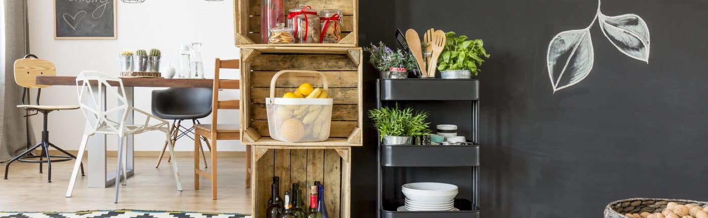 Essbereich mit Holztisch, kreativer Regallösung und Kräuterwagen.