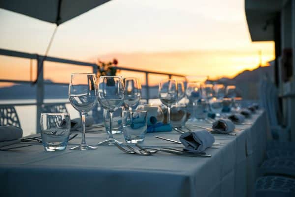 Ein gedeckter Tisch mit Weingläsern steht im Abendlicht.