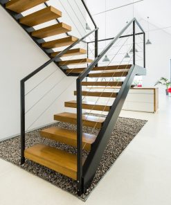 Das Bild zeigt eine moderne Stahltreppe mit Holzstufen in einem hellen Raum.