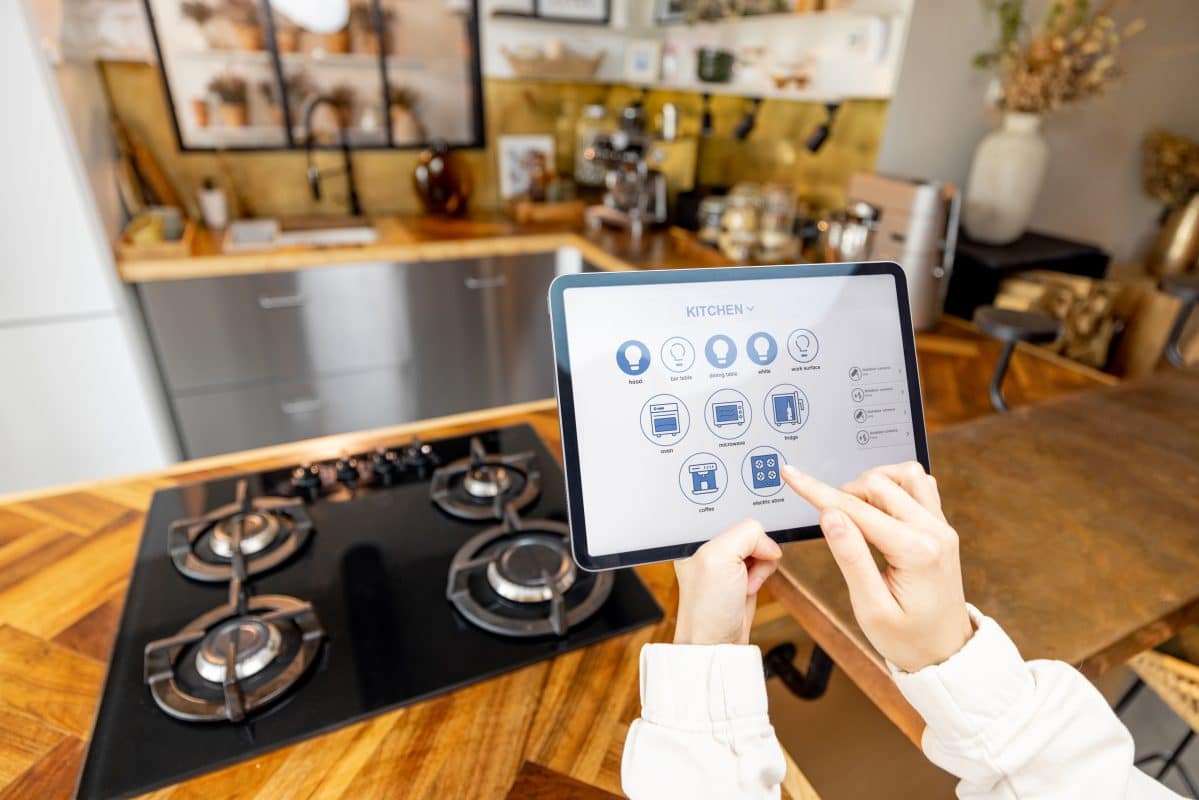 Tablet steuert Smart-Home-Geräte in moderner Küche.