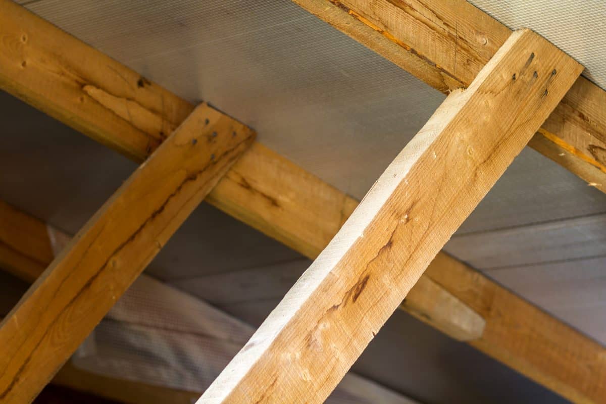 Holzbalken eines Dachstuhls mit Dämmung und Unterspannbahn.